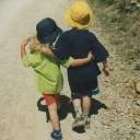 Ein altes Kinderfoto von Vanessa und Philipp, sie laufen Arm in Arm einen Waldweg entlang.