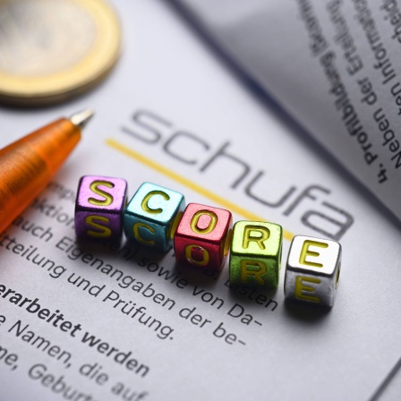 Buchstabenwürfel bilden das Wort "Score" auf einem Formular der Schufa
