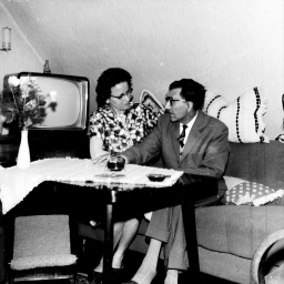 Schwarz-weiß Foto: Eine Frau und ein Mann unterhalten sich in einem Wohnzimmer, ca. 1960er Jahre. 