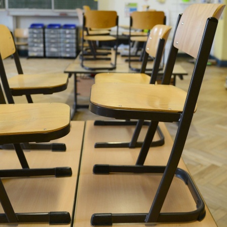 Stühle stehen in einer Grundschule nach Unterrichtsende auf den Tischen