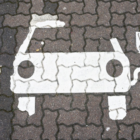 Ein Symbol markiert einen Parkplatz für Elektroautos an Ladesäulen für E-Autos an einem Rastplatz an der Autobahn.