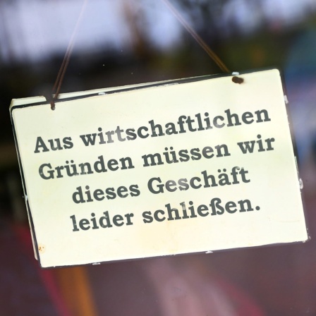 Schild mit der Aufschrift "Aus wirtschaftlichen Gründen müssen wir dieses Geschäft leider schließen".