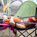 Eine Besucherin beim Open-Air-Festival "Rock im Park" entspannt sich auf einer Liege aus zwei Stühlen gestaltet.