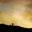 Ein Engel steht auf einem Berg unter einem Regenbogen