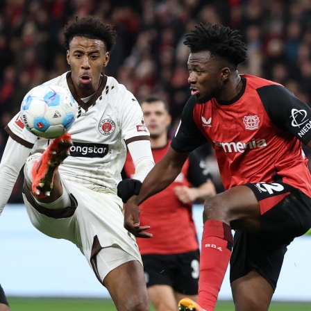 Morgan Guilavogui vom FC St. Pauli im Zweikampf mit Edmond Tapsoba von Bayer 04 Leverkusen