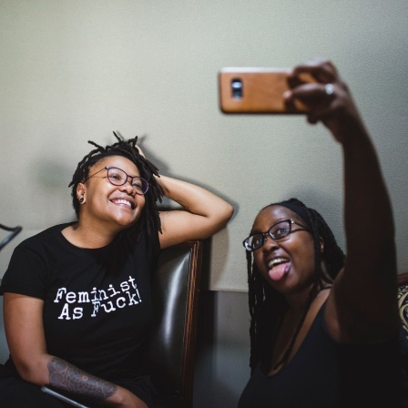 Tiffany Mugo macht im Studio ein Selfie mit einer anderen Frau.
